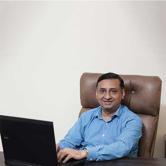 Waseem Javed, Founder of Talent Zone Academy, seated at his office desk with a laptop, symbolizing leadership and strategic growth in education